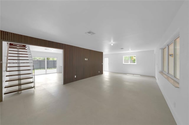 spare room with wood walls, baseboards, and visible vents