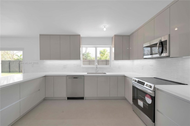 kitchen with stainless steel appliances, modern cabinets, a sink, and gray cabinets