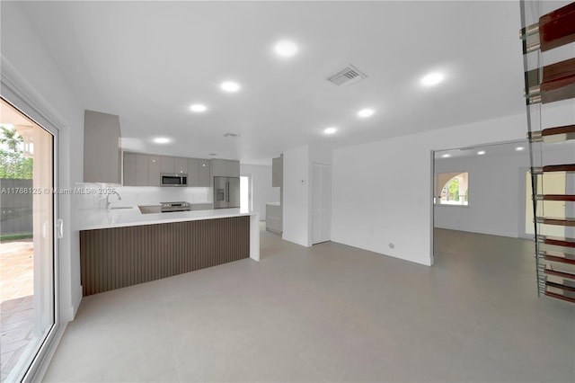unfurnished living room with concrete flooring, visible vents, and recessed lighting