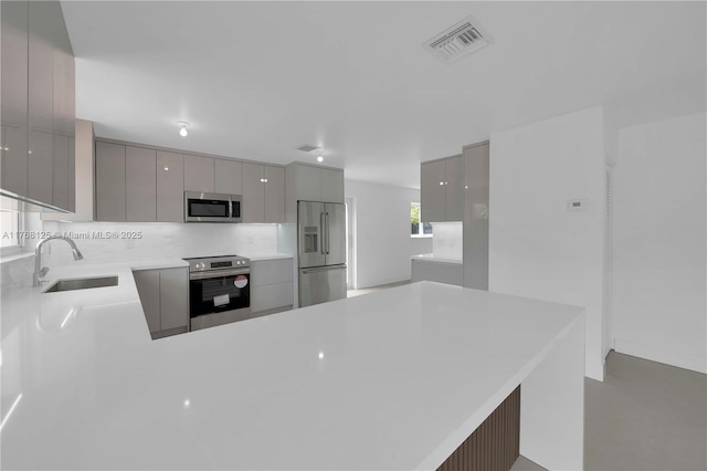 kitchen featuring gray cabinets, visible vents, modern cabinets, appliances with stainless steel finishes, and a sink