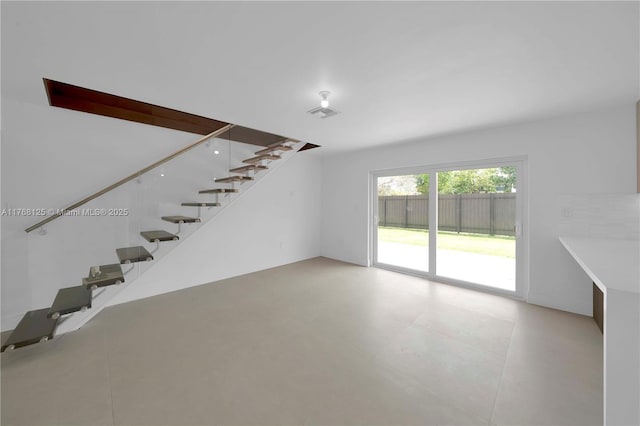 unfurnished living room with visible vents and stairs