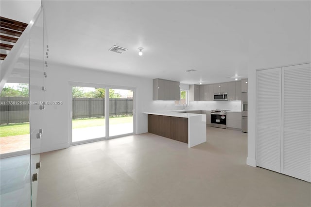 kitchen with appliances with stainless steel finishes, a sink, modern cabinets, and visible vents