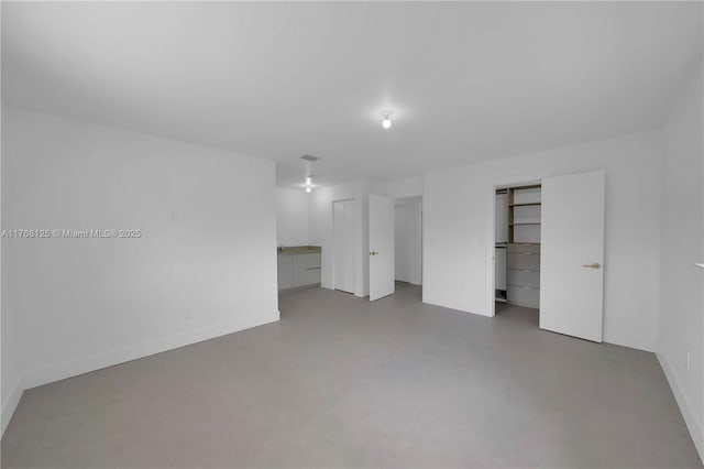 unfurnished bedroom featuring concrete floors and baseboards