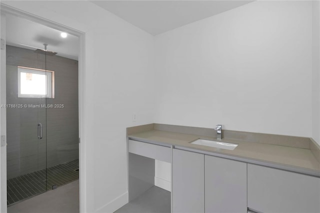 full bathroom with baseboards, a stall shower, and vanity