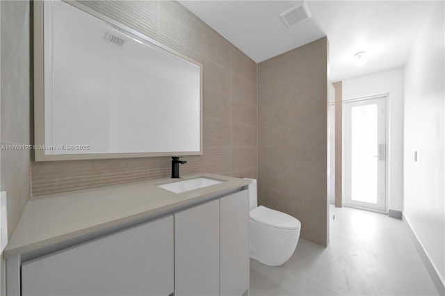 bathroom with vanity, visible vents, baseboards, and toilet