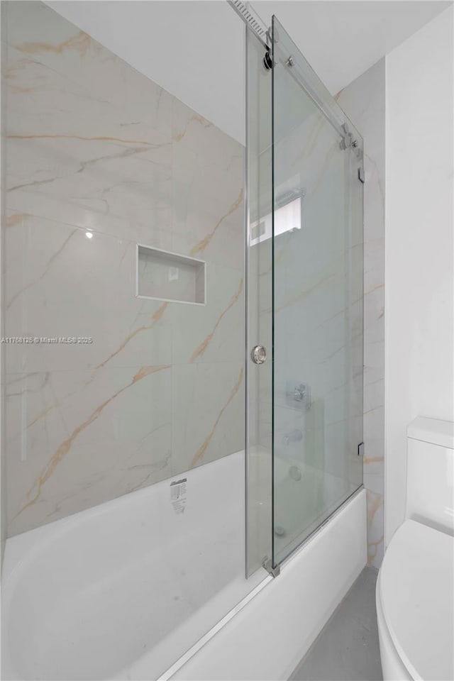 full bathroom with toilet and shower / bath combination with glass door