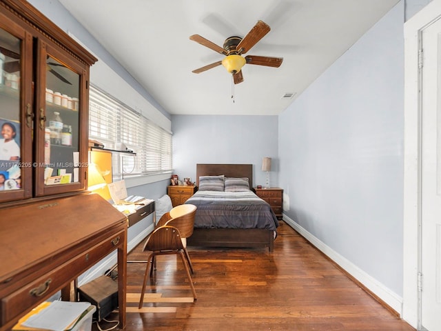 bedroom featuring baseboards, visible vents, and wood finished floors
