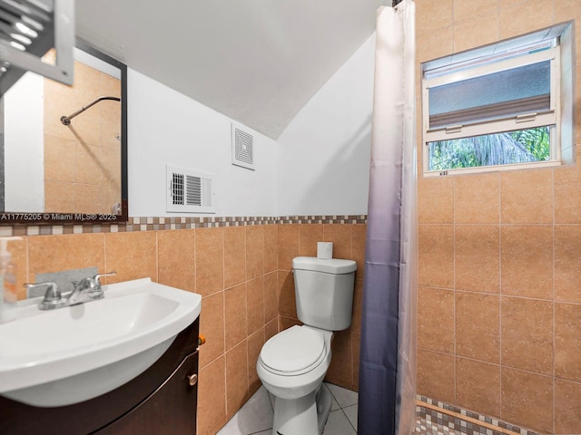 bathroom with vanity, tile walls, toilet, visible vents, and curtained shower