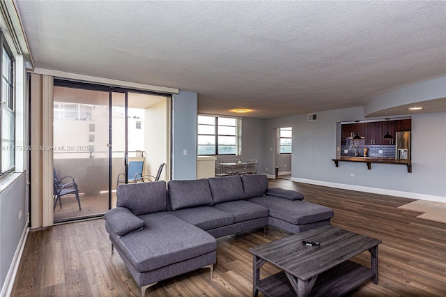 9180 W Bay Harbor Dr Unit 5C, Bay Harbor Islands, FL 33154 - living area featuring a textured ceiling, baseboards, and wood finished floors