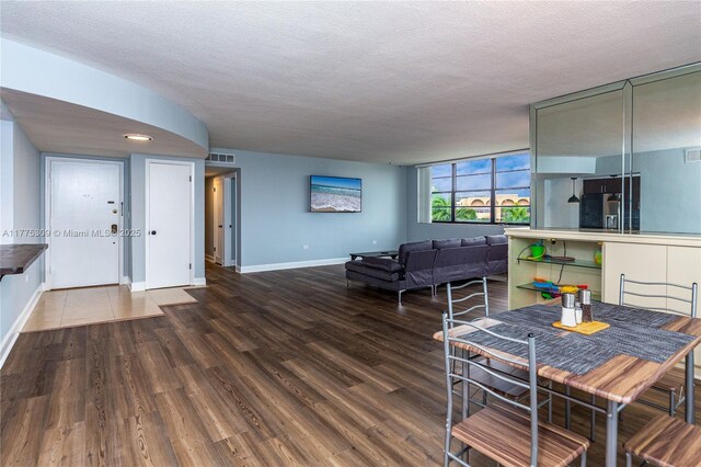 9180 W Bay Harbor Dr Unit 5C, Bay Harbor Islands, FL 33154 - dining room featuring wood finished floors, baseboards, and a textured ceiling