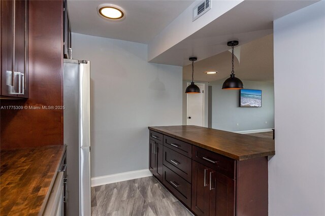 9180 W Bay Harbor Dr Unit 5C, Bay Harbor Islands, FL 33154 - kitchen featuring butcher block counters, baseboards, freestanding refrigerator, dark brown cabinets, and decorative light fixtures