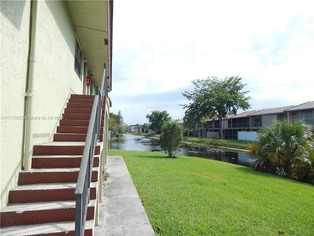 view of yard with a water view and stairway
