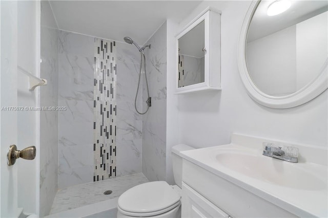 bathroom featuring toilet, vanity, and a marble finish shower