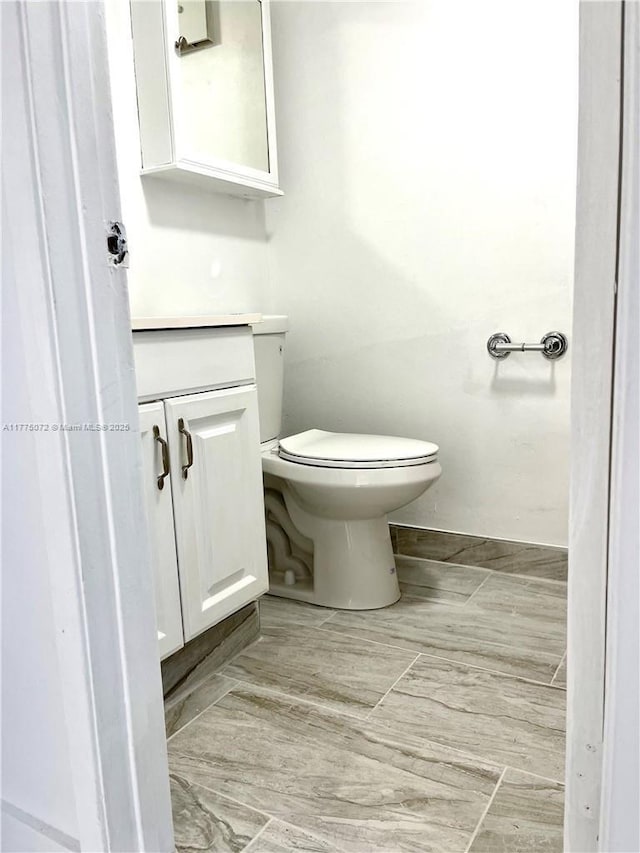 half bath featuring toilet and vanity