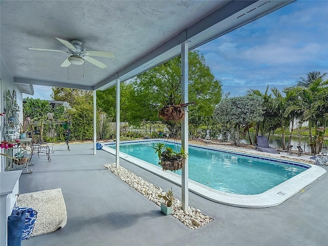view of swimming pool featuring a fenced in pool, a ceiling fan, a fenced backyard, and a patio