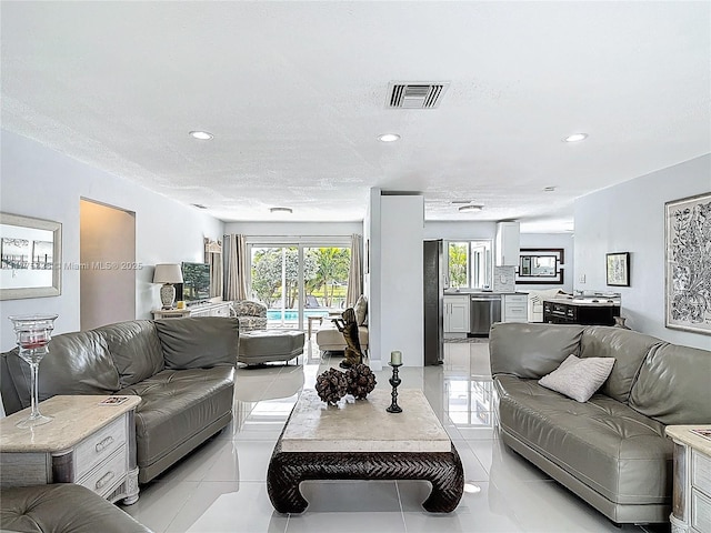 living area featuring light tile patterned floors, recessed lighting, and visible vents