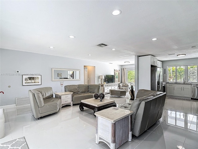 living area featuring visible vents, recessed lighting, plenty of natural light, and light tile patterned flooring