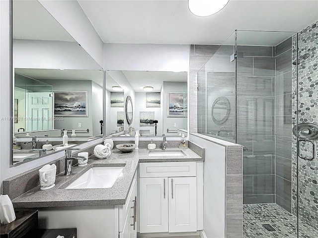 full bath with double vanity, a shower stall, and a sink