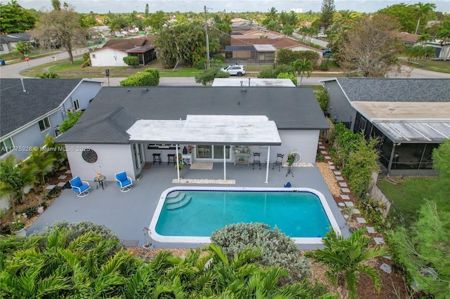 outdoor pool with a residential view and a patio area