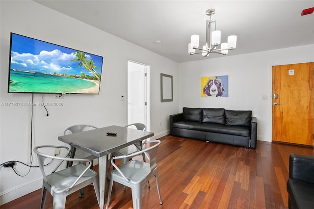 dining space featuring baseboards, a chandelier, and wood finished floors