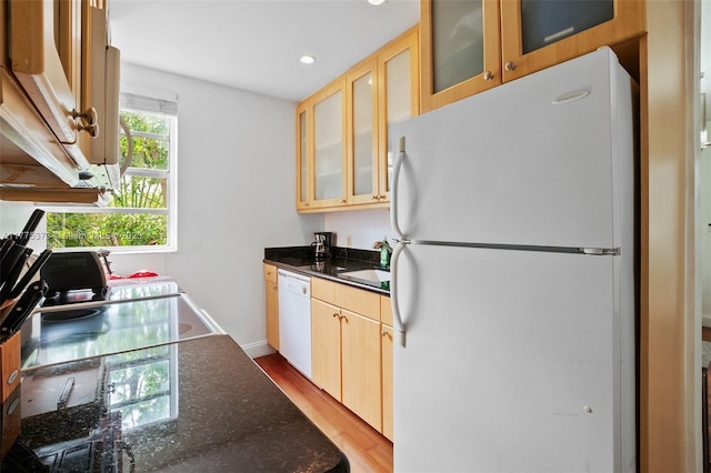 kitchen with recessed lighting, white appliances, glass insert cabinets, light wood-style floors, and a sink