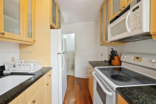 kitchen with glass insert cabinets, baseboards, white appliances, dark stone counters, and dark wood-type flooring
