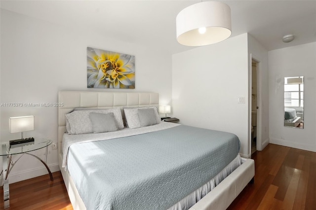 bedroom featuring baseboards and wood finished floors