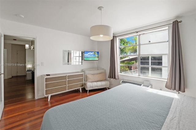 bedroom featuring wood finished floors and a notable chandelier