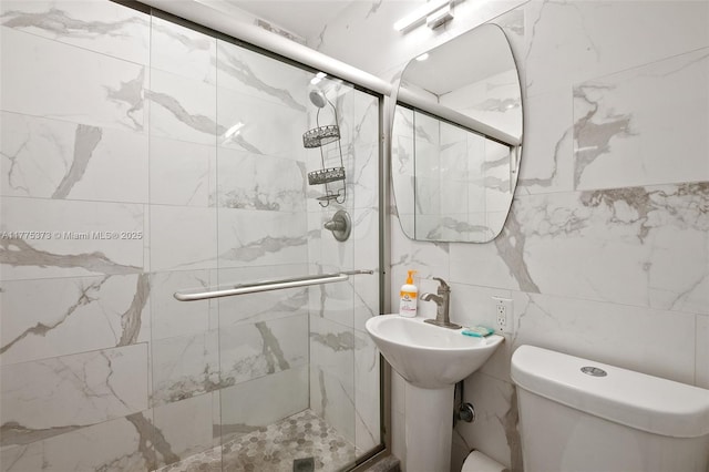 bathroom featuring a shower stall, tile walls, and toilet
