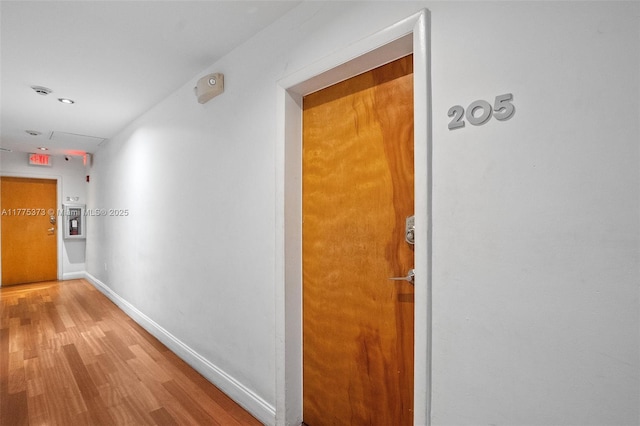 hall with recessed lighting, light wood finished floors, and baseboards
