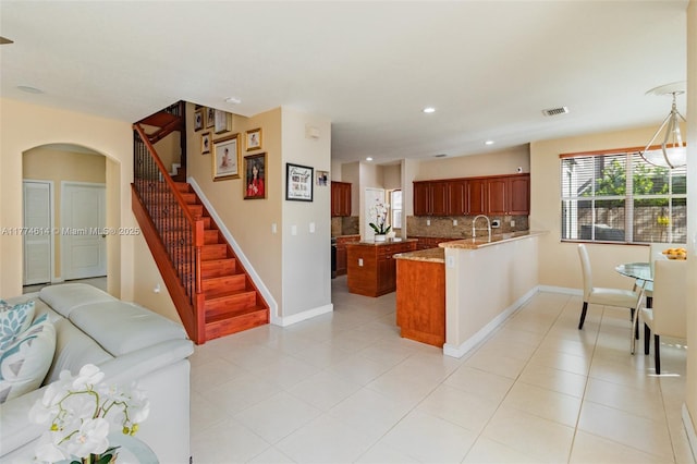 1411 SW 149th Pl, Miami, FL 33194 - kitchen with a peninsula, decorative backsplash, open floor plan, arched walkways, and recessed lighting