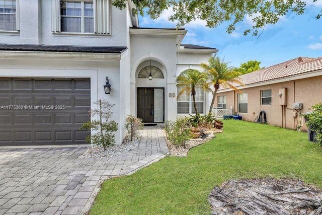 10766 Crescendo Cir, Boca Raton, FL 33498 - entrance to property featuring stucco siding, a yard, and an attached garage