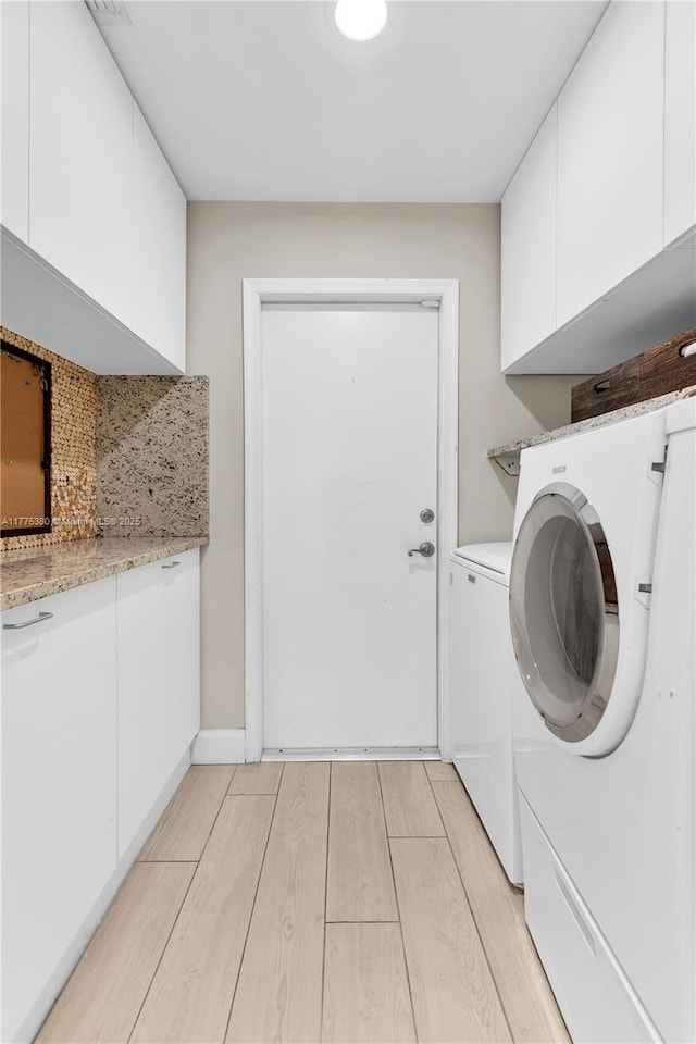 10766 Crescendo Cir, Boca Raton, FL 33498 - washroom featuring independent washer and dryer, light wood-style flooring, and cabinet space