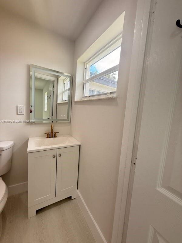 4529 SW 24th St, Fort Lauderdale, FL 33317 - half bath featuring toilet, wood finished floors, vanity, and baseboards