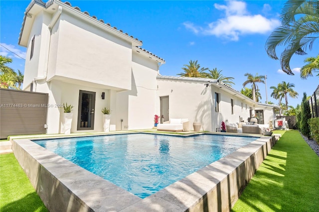 view of pool with a patio area, outdoor lounge area, a lawn, fence, and a fenced in pool