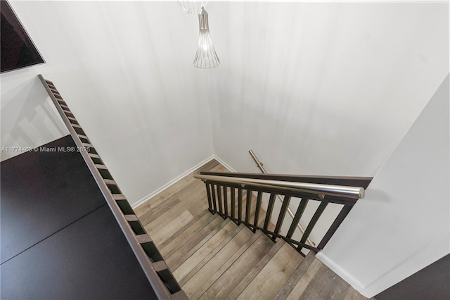 stairs featuring wood finished floors and baseboards