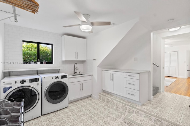 laundry room with baseboards, separate washer and dryer, a sink, a ceiling fan, and cabinet space