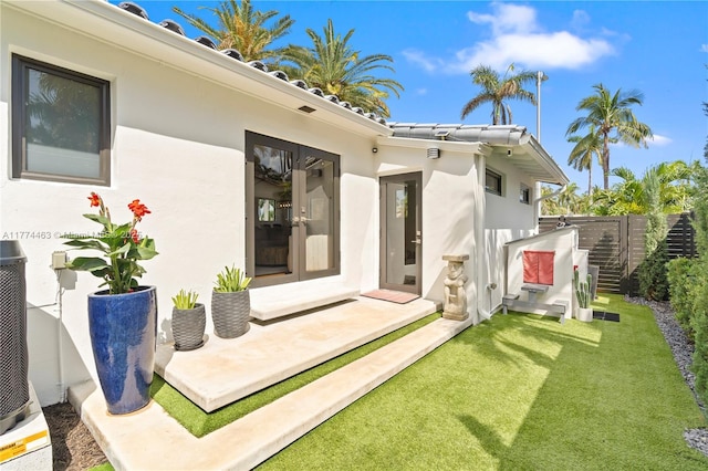 exterior space with a yard, stucco siding, and fence
