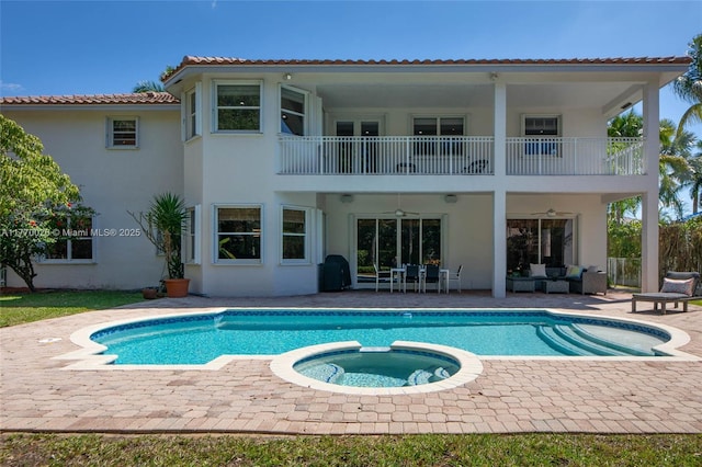 rear view of house with a tiled roof, a patio, an outdoor hangout area, stucco siding, and a balcony