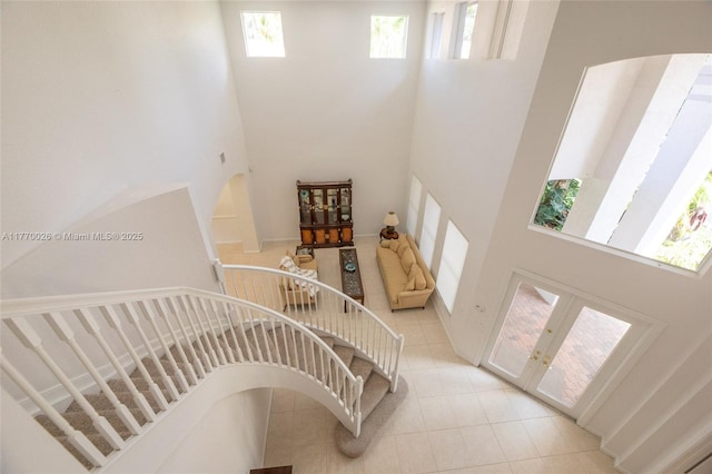 stairway with a wealth of natural light and a towering ceiling