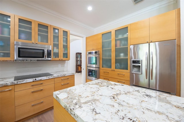 kitchen featuring glass insert cabinets, crown molding, light stone countertops, backsplash, and stainless steel appliances