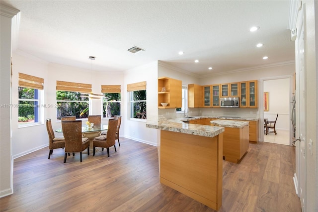kitchen featuring stainless steel microwave, baseboards, recessed lighting, a peninsula, and a sink