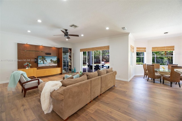 living room with visible vents, baseboards, and wood finished floors