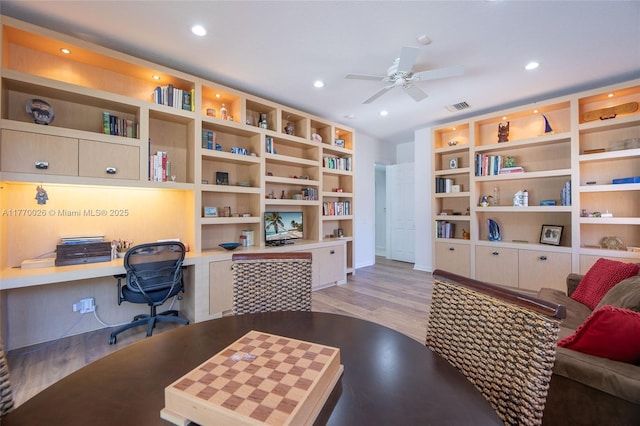 home office featuring light wood-type flooring, built in desk, recessed lighting, a ceiling fan, and visible vents