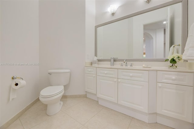 bathroom with toilet, vanity, baseboards, and tile patterned flooring