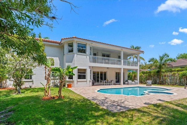1427 Victoria Isle Dr, Weston, FL 33327 - rear view of house featuring a balcony, a lawn, a patio, a tile roof, and stucco siding