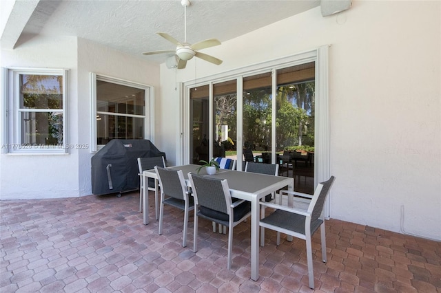 view of patio featuring area for grilling, ceiling fan, and outdoor dining area