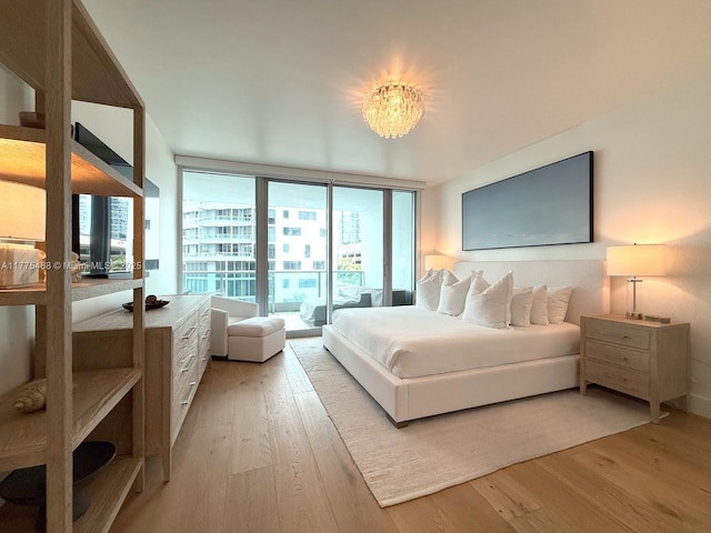 1331 Brickell Bay Dr Unit 506, Miami, FL 33131 - bedroom with light wood finished floors, floor to ceiling windows, access to outside, and a chandelier