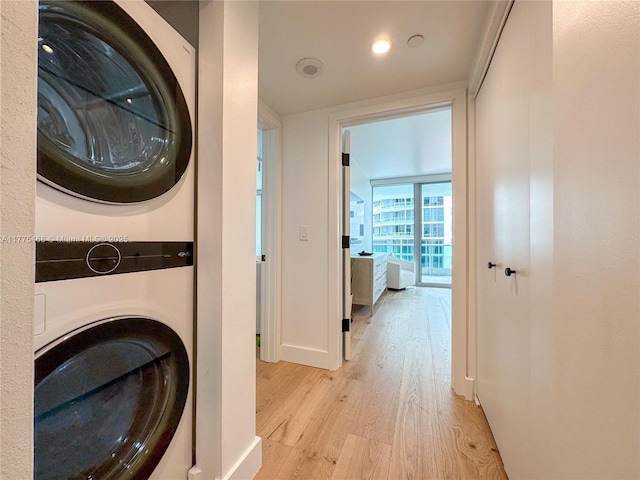 1331 Brickell Bay Dr Unit 506, Miami, FL 33131 - washroom featuring stacked washer and clothes dryer, light wood-type flooring, baseboards, and recessed lighting