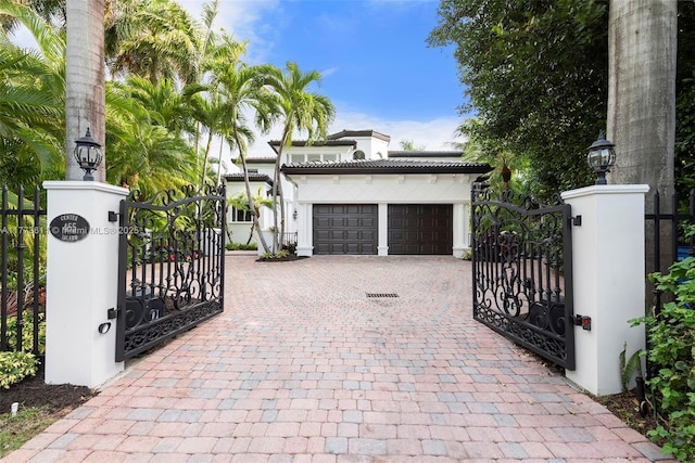 455 Centre Is, Golden Beach, FL 33160 - exterior space featuring a garage, fence, decorative driveway, stucco siding, and a gate